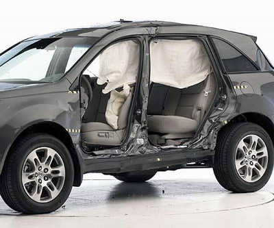 View of the vehicle after the crash with doors removed, showing the side airbags and damage to the occupant compartment