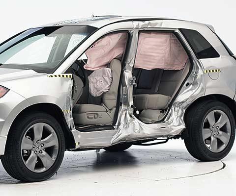 View of the vehicle after the crash with doors removed, showing the side airbags and damage to the occupant compartment