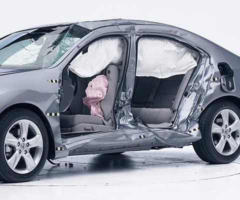 View of the vehicle after the crash with doors removed, showing the side airbags and damage to the occupant compartment