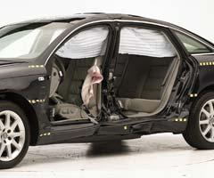 View of the vehicle after the crash with doors removed, showing the side airbags and damage to the occupant compartment