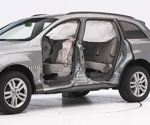 View of the vehicle after the crash with doors removed, showing the side airbags and damage to the occupant compartment