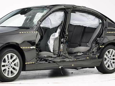 View of the vehicle after the crash with doors removed, showing the side airbags and damage to the occupant compartment