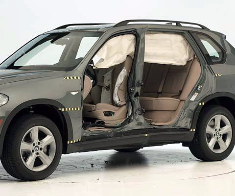 View of the vehicle after the crash with doors removed, showing the side airbags and damage to the occupant compartment