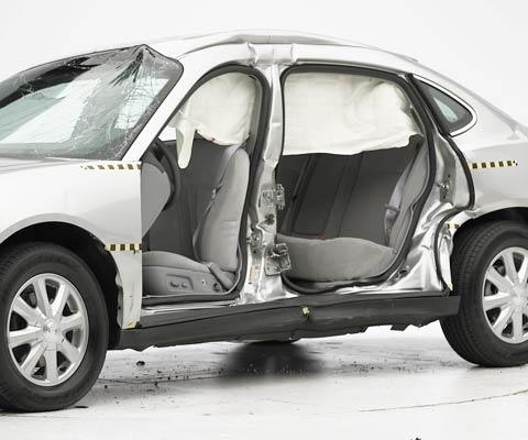 View of the vehicle after the crash with doors removed, showing the side airbag and damage to the occupant compartment