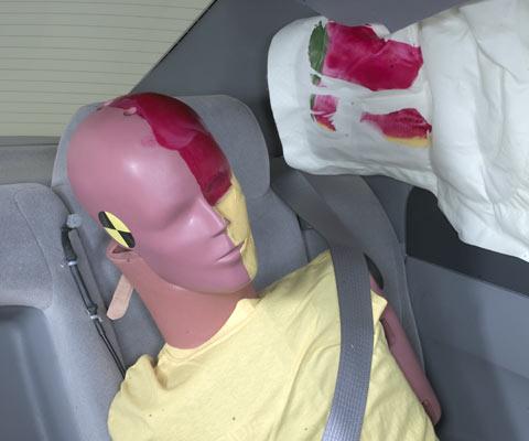 Action shot taken during the side impact crash test showing the driver dummy's head was protected from being hit by hard structures by the side curtain airbag