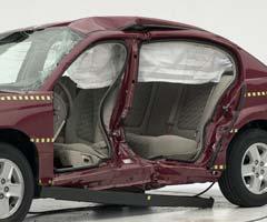 View of the vehicle after the crash with doors removed, showing the side airbag and damage to the occupant compartment.