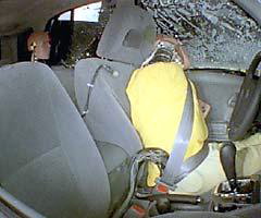 Action shot taken during the side impact crash test showing the driver dummy's head being hit by the intruding barrier