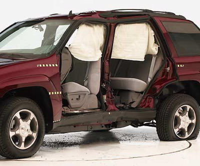 View of the vehicle after the crash with doors removed, showing the side airbag and damage to the occupant compartment