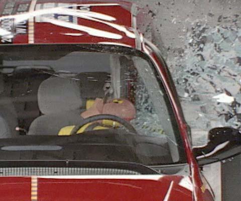 Action shot taken during the side impact crash test showing the driver dummy's head leaning well outward and hitting the crash test barrier