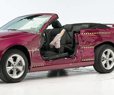 View of the vehicle after the crash with door removed, showing the side airbag and damage to the occupant compartment