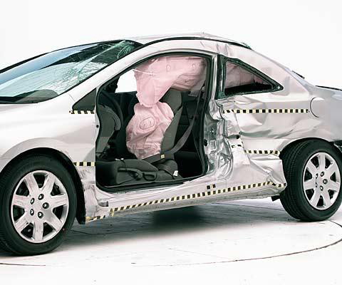 View of the vehicle after the crash with door removed, showing the side airbags and damage to the occupant compartment