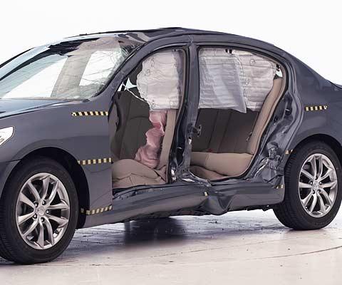 View of the vehicle after the crash with doors removed, showing the side airbags and damage to the occupant compartment