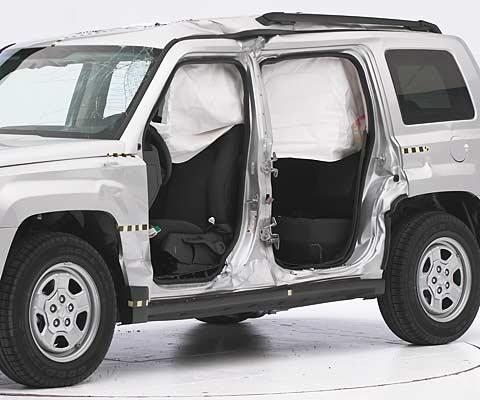 View of the vehicle after the crash with doors removed, showing the side airbag and damage to the occupant compartment