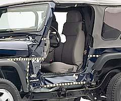 View of the vehicle after the crash with door removed, showing damage to the occupant compartment