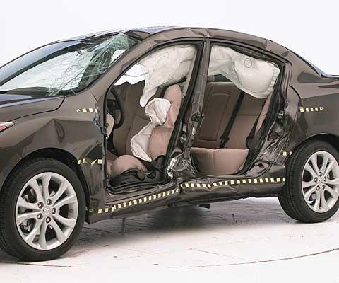 View of the vehicle after the crash with doors removed, showing the side airbags and damage to the occupant compartment