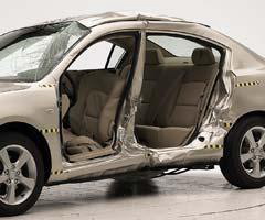 View of the vehicle after the crash with doors removed, showing the side airbags and damage to the occupant compartment