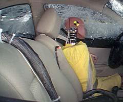 Action shot taken during the side impact crash test showing the driver dummy's head being hit by the intruding barrier