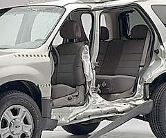 View of the vehicle after the crash with doors removed, showing the side airbags and damage to the occupant compartment