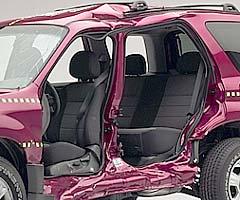 View of the vehicle after the crash with doors removed, showing the side airbags and damage to the occupant compartment