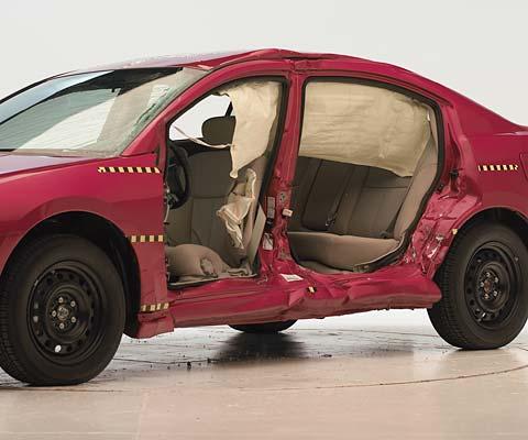 View of the vehicle after the crash with doors removed, showing the side airbags and damage to the occupant compartment