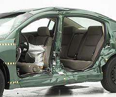 View of the vehicle after the crash with doors removed, showing the side airbag and damage to the occupant compartment