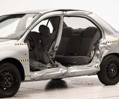 View of the vehicle after the crash with doors removed, showing damage to the occupant compartment