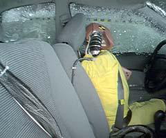 Action shot taken during the side impact crash test showing the driver dummy's head being hit by the intruding barrier