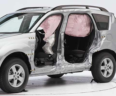 View of the vehicle after the crash with doors removed, showing the side airbags and damage to the occupant compartment