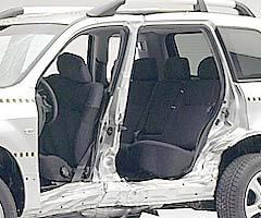 View of the vehicle after the crash with doors removed, showing damage to the occupant compartment