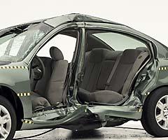 View of the vehicle after the crash with doors removed, showing the side airbags and damage to the occupant compartment