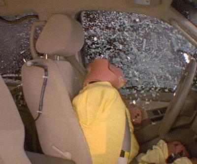 Action shot taken during the side impact crash test showing the driver dummy's head leaning well outward and approaching the window sill