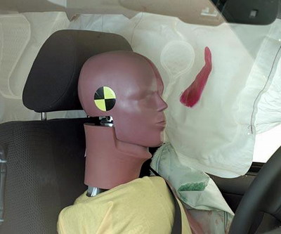 Action shot taken during the side impact crash test showing the driver dummy's head leaning well outward and approaching the window sill