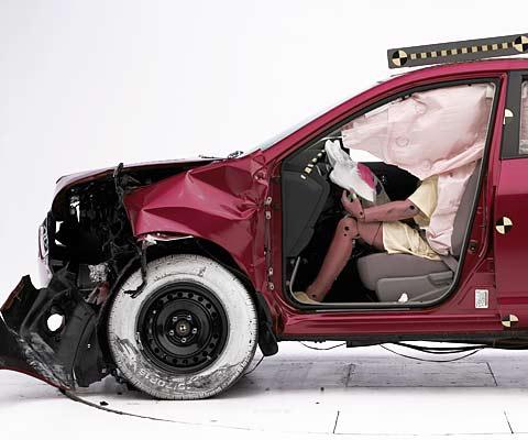 The dummy's position in relation to the steering wheel and instrument panel after the crash test indicates that the driver's survival space was maintained well (dummy's head obscured by deployed side curtain airbag)