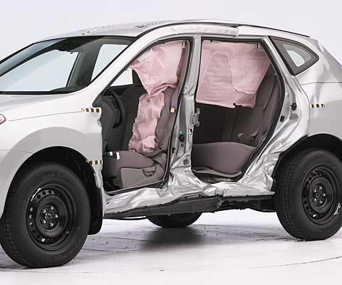 View of the vehicle after the crash with doors removed, showing the side airbags and damage to the occupant compartment