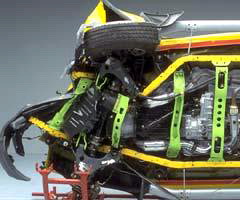 A strong safety cage helped keep the tire from buckling the sill beneath the driver door, maintaining the integrity of the occupant compartment. Crumpled structure in front of the occupant compartment indicates where the crash energy was absorbed