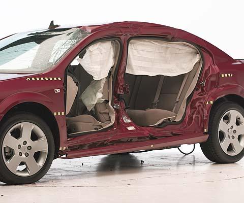 View of the vehicle after the crash with doors removed, showing the side airbags and damage to the occupant compartment