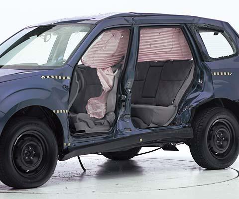 View of the vehicle after the crash with doors removed, showing the side airbags and damage to the occupant compartment