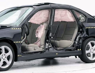 View of the vehicle after the crash with doors removed, showing the side airbags and damage to the occupant compartment