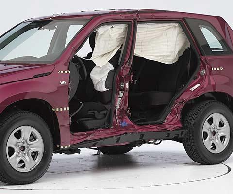 View of the vehicle after the crash with doors removed, showing the side airbags and damage to the occupant compartment