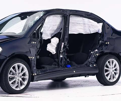 View of the vehicle after the crash with doors removed, showing the side airbags and damage to the occupant compartment