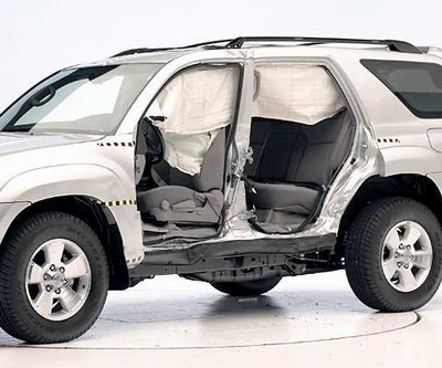 View of the vehicle after the crash with doors removed, showing the side airbag and damage to the occupant compartment