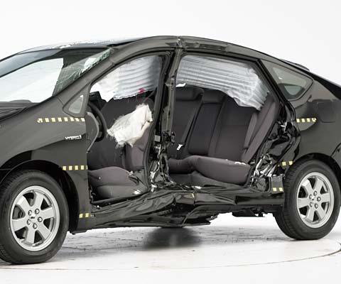 View of the vehicle after the crash with door removed, showing the side airbags and damage to the occupant compartment