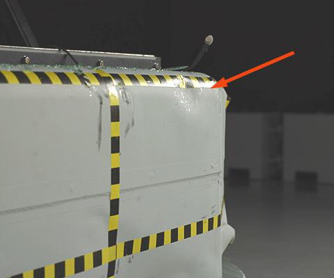 A prominent dent and scrape marks indicate where the driver dummy's head hit the barrier