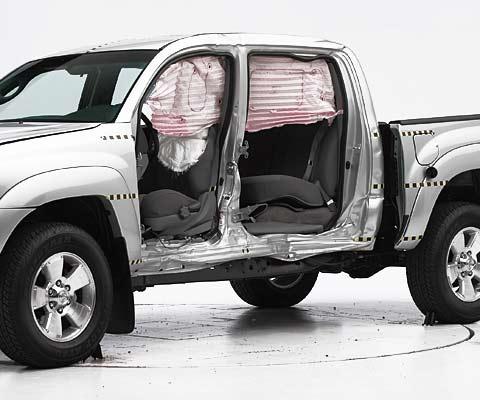 View of the vehicle after the crash with doors removed, showing the side airbags and damage to the occupant compartment