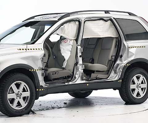 View of the vehicle after the crash with doors removed, showing the side airbags and damage to the occupant compartment