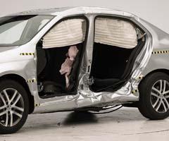 View of the vehicle after the crash with doors removed, showing the side airbags and damage to the occupant compartment