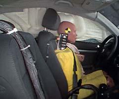 Action shot taken during the side impact crash test showing the driver dummy's head was protected from being hit by hard structures by the side curtain airbag