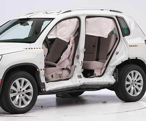 View of the vehicle after the crash with doors removed, showing the side airbags and damage to the occupant compartment